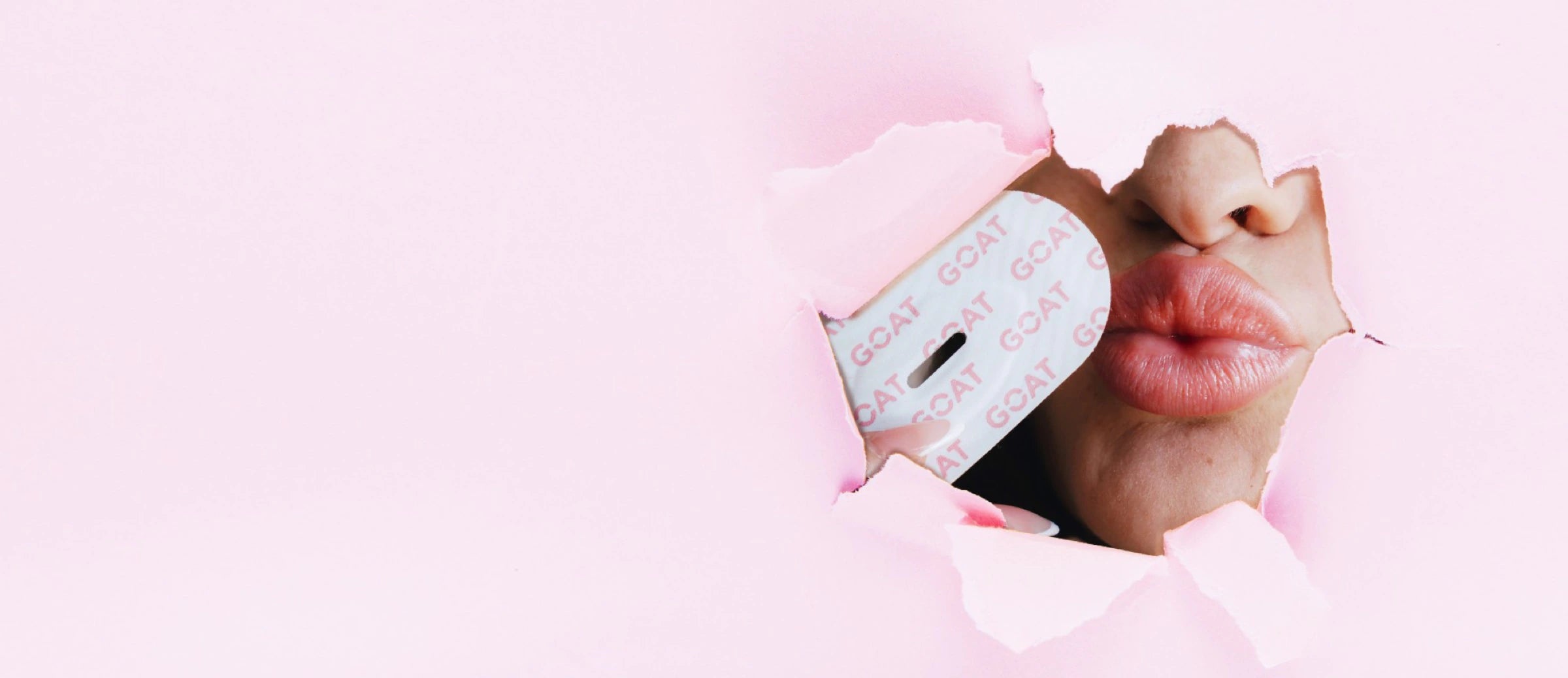 Lips kissing GOAT collagen mouth tape through torn pink paper