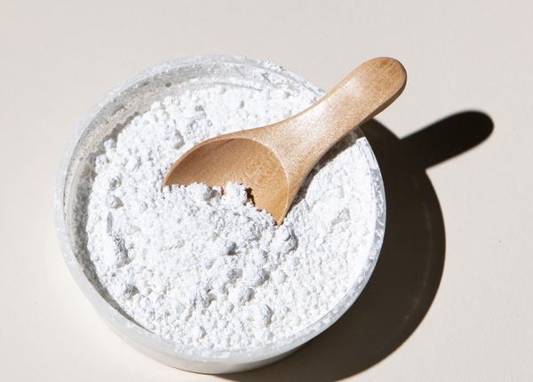 Marine collagen powder in a stone bowl with a wooden scoop