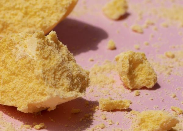Golden CoQ10 powder crumbled on a pink ground