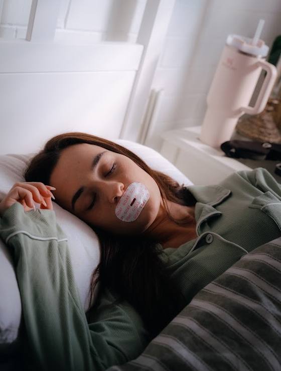 Woman asleep on her side wearing the collagen mouth tape
