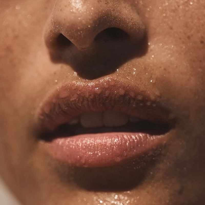 Macro of dewy lips and nose, skin beaded with moisture