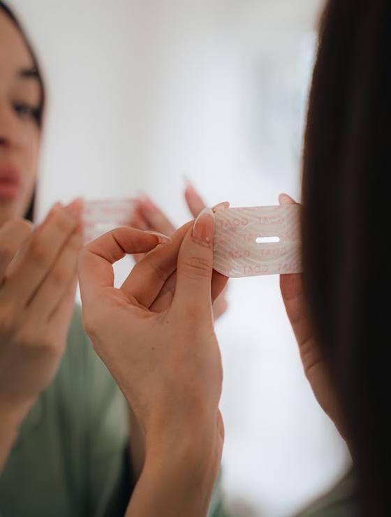 Hands peeling the tape from its backing